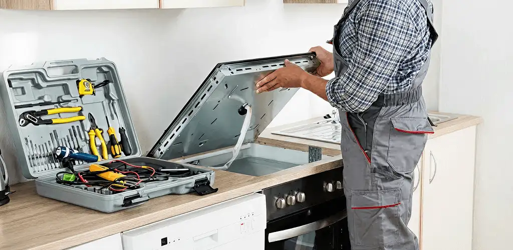 Handyman repairing a cooktop and checking wiring connections in Saint Louis, MO