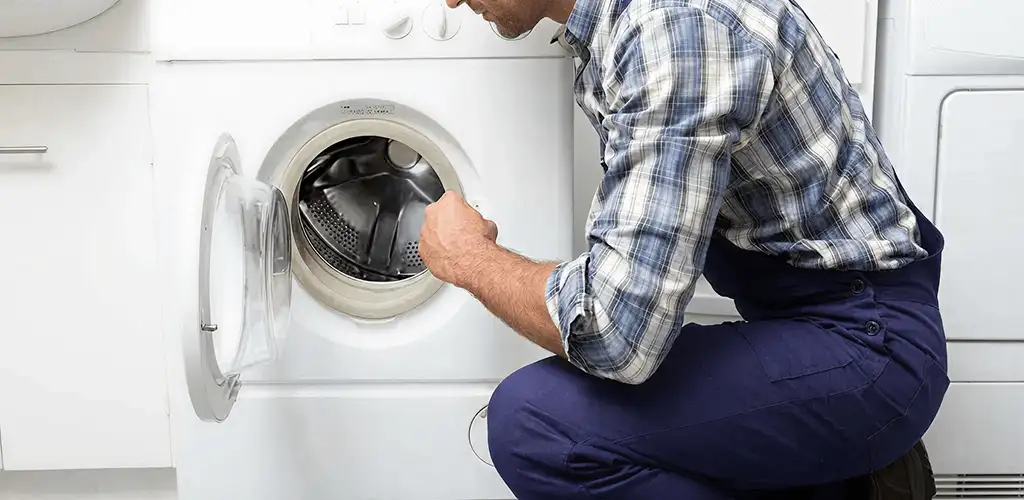 Handyman inspecting a dryer drum and internal parts for repair in Saint Louis, MO