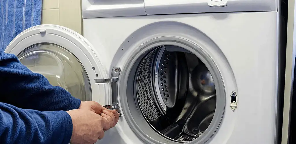 Washing machine repair handyman checking a front-load washer door and latch in Saint Louis, MO